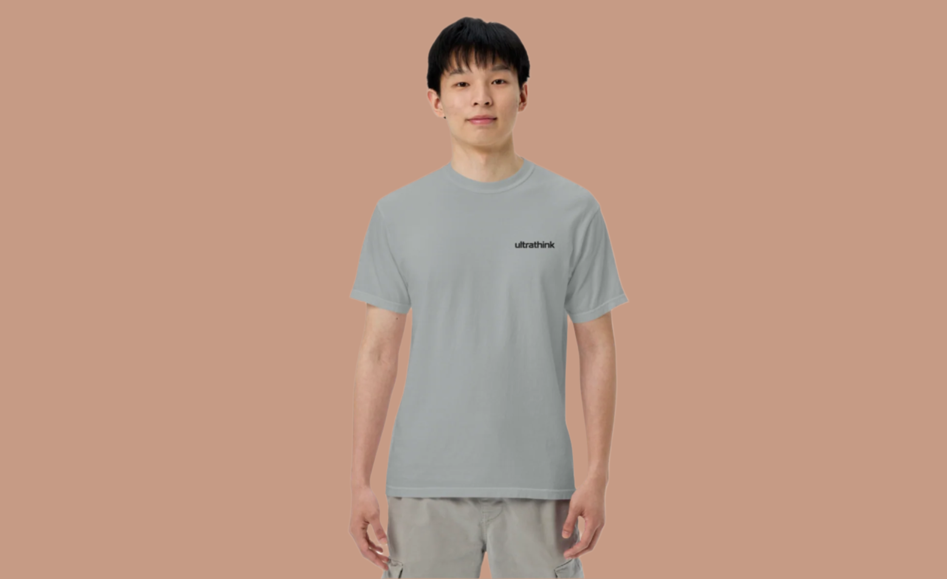 Person wearing a gray t-shirt with a logo on a white background